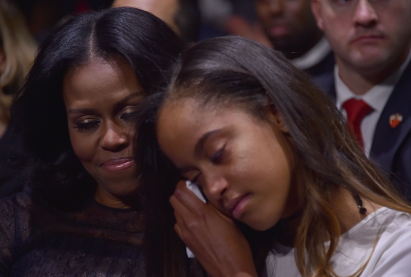 First lady Michelle Obama holds her daughter Malia as President Barack Obama speaks during his farewell address in Chicago on Jan. 10, 2017. NICHOLAS KAMM/AFP/Getty Images